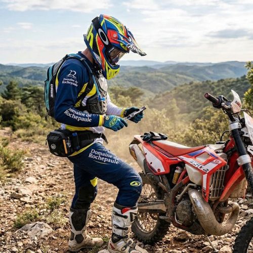 Pilote utilisant ses outils moto off road sur un chemin rocailleux, illustrant l'équipement indispensable pour une randonnée moto enduro.